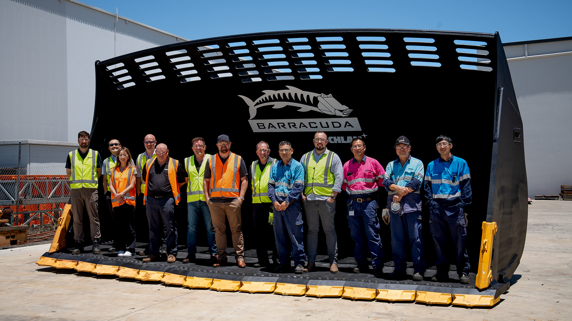 Schlam's engineering and manufacturing teams standing inside Glencore's big CAT 995 Barracuda bucket.