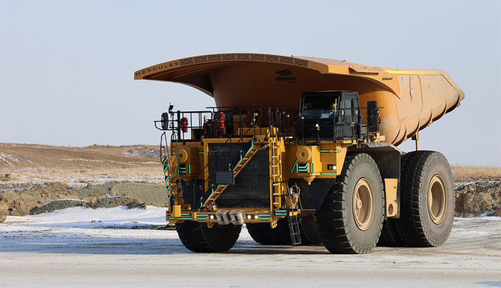 Front view of a heavy-duty mining haul truck with a Hercules lightweight truck bed used to improve payload and reduce haulage costs