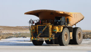 Front view of a heavy-duty mining haul truck with a Hercules lightweight truck bed used to improve payload and reduce haulage costs